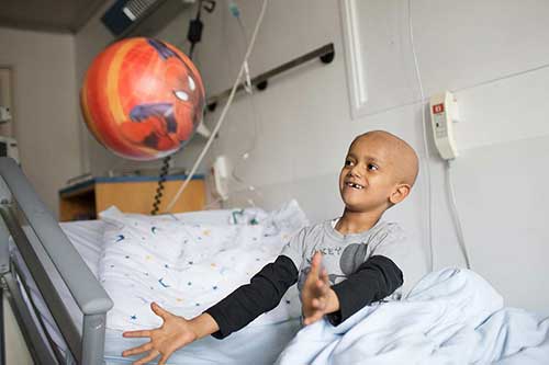young patient playing in their hospital bed