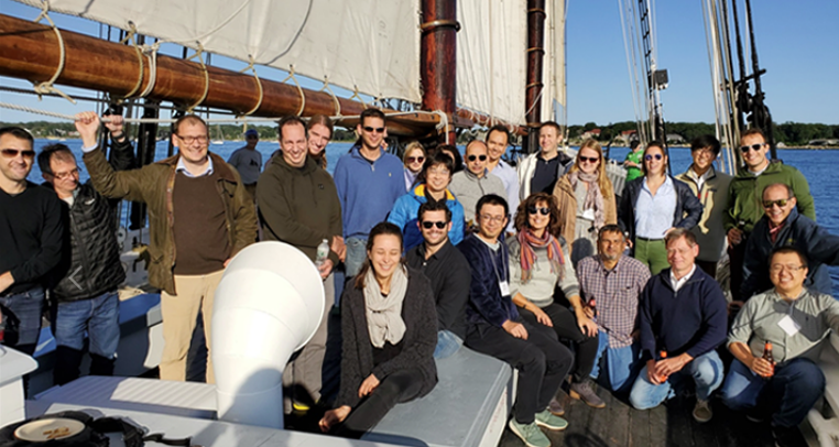 Photo of approximately 30 smiling people grouped together on a boat